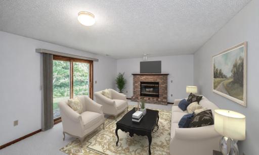 Virtually staged family room on the walkout third level and is warmed by a brick surround wood-burning fireplace.