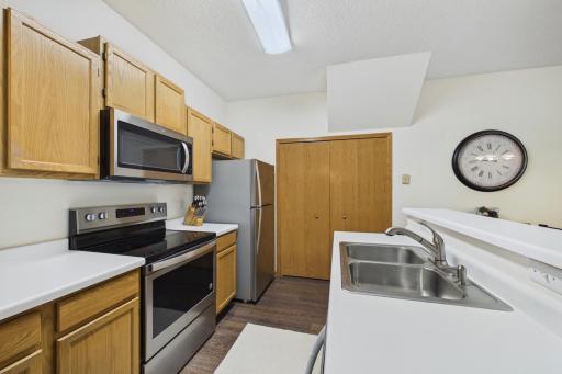 Efficient kitchen layout with stainless steel appliances, abundant cabinetry, breakfast bar, and adjacent main floor laundry.