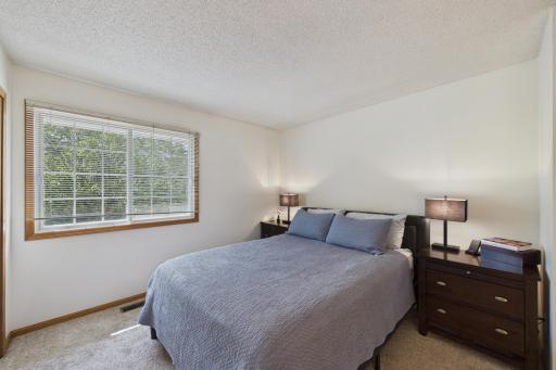 Generously sized second bedroom with large window, neutral finishes, and ample space for guests or everyday living.