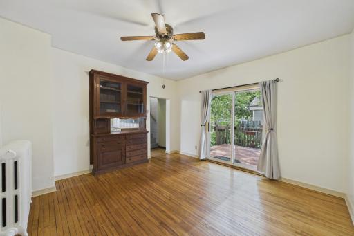 Spacious dining room featuring sliding glass doors to the deck, a charming built-in cabinet for added character and storage, and a convenient pass-through opening to the kitchen that creates great flow for entertaining and everyday living.