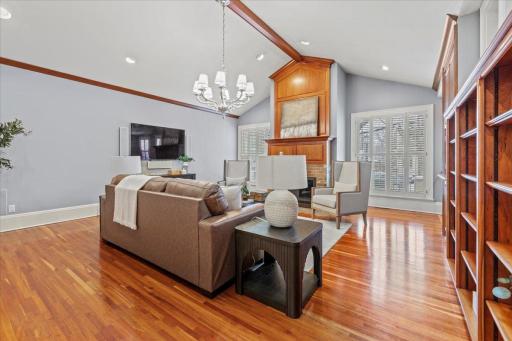 Expansive second living space on the main level, featuring dramatic vaulted ceilings, plentiful natural light, a fireplace, custom cabinetry, and adaptable design for endless possibilities