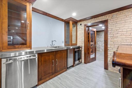 Wet bar with premium refrigerator, sink, and dishwasher, flowing seamlessly into a show-stopping wine room
