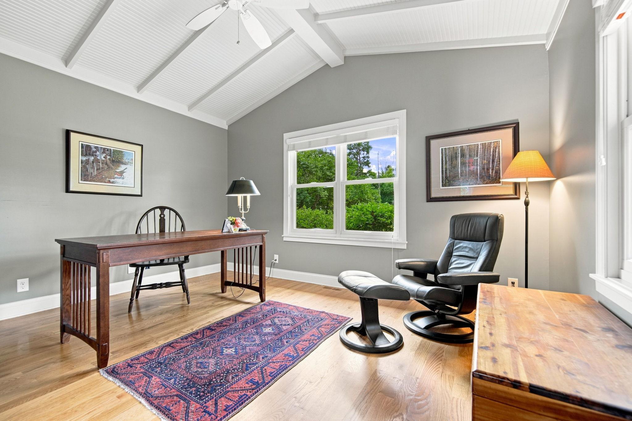 Second main level bedroom. Staged as an office space. Vaulted ceilings