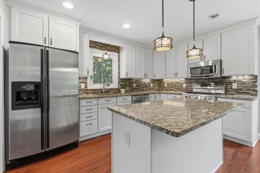 Kitchen features enameled cabinetry, eat-in center island and granite countertops