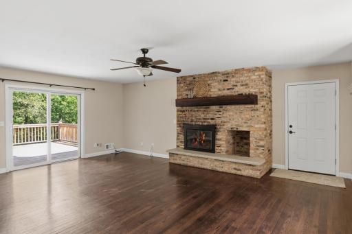 Wood-burning fireplace with brick surround. Door leads to the oversized 2-car garage!