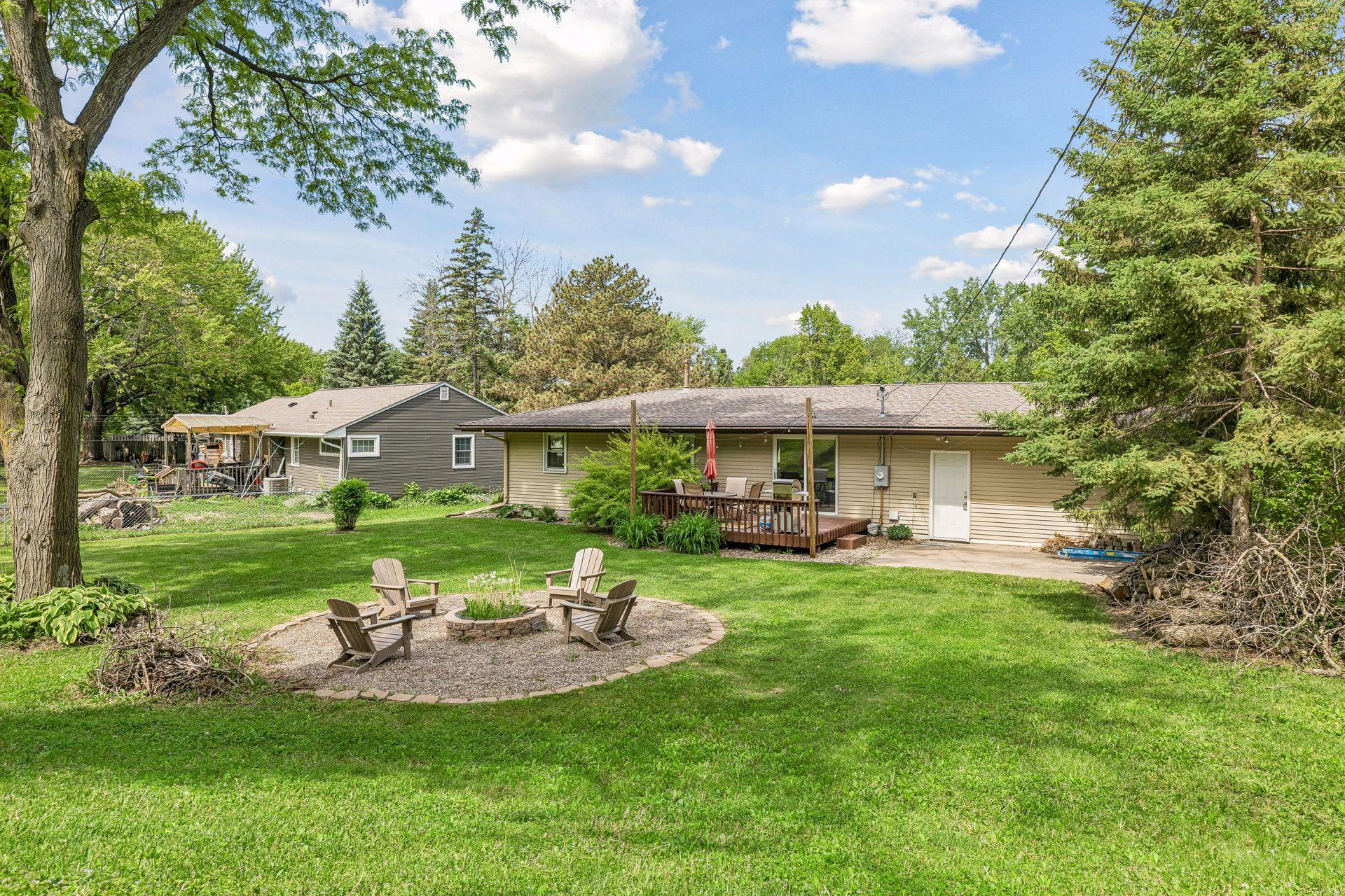 The large backyard has a deck, concrete patio, and firepit