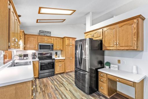 The kitchen features abundant cabinet storage, ample countertops, updated black stainless steel appliances, and a built-in planning desk for added functionality.