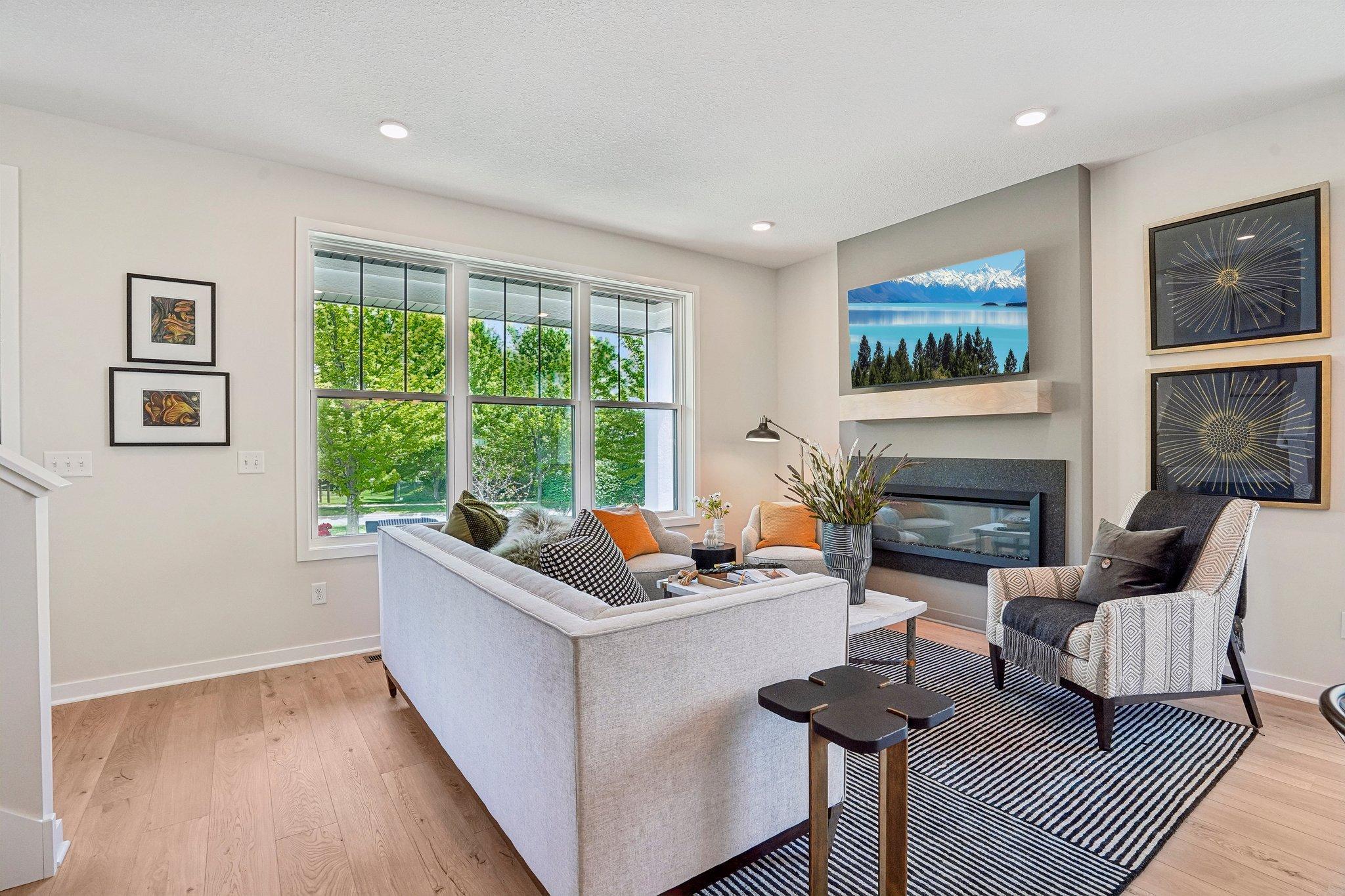 Sophisticated main level with durable SPC flooring, anchored by a statement fireplace with granite surround and wood mantle.