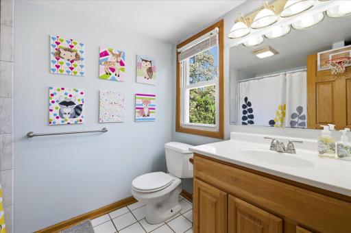 Upper level full bathroom with window looking out to backyard.