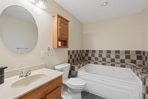 The spacious lower level bathroom features a relaxing soaking tub, perfect for unwinding after a long day.