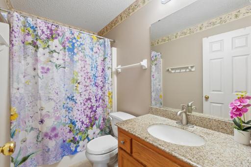Full bathroom on the upper level featuring solid surface vanity top.