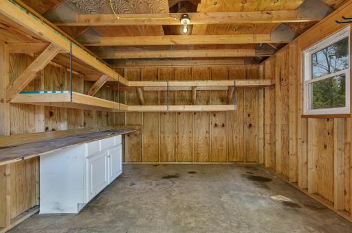 Interior of the accessory/garden shed with shelving, cabinetry and lighting.