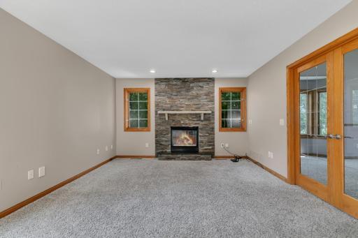 The family room is anchored by a beautiful gas fireplace featuring stone accents, a substantial stone mantel, and a granite hearth ledge.