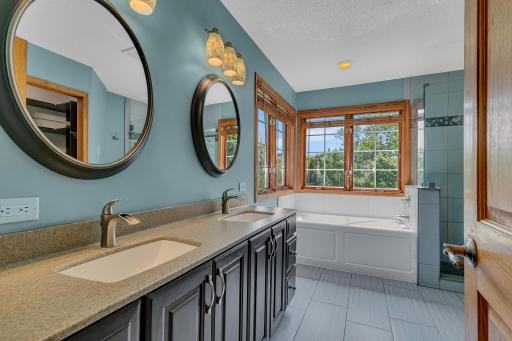 The primary suiteâs private bath features dual sinks, tiled flooring, a jetted tub.