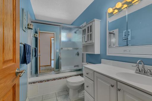A second full bathroom with tiled flooring, a jetted tub, and built-in medicine cabinet serves the upper level, along with a convenient hallway linen closet.