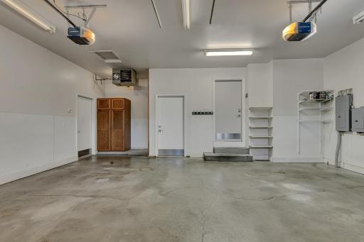 The finished three-stall garage is a standout feature, offering three individual overhead doors with separate openers, keyless entry pads, smart technology, and a heated two-stall section.