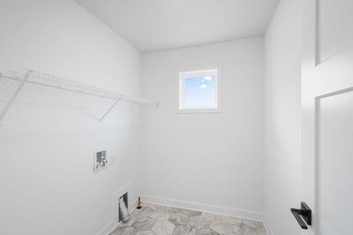 The laundry room features washer and dryer hook-ups and shelving for storage.