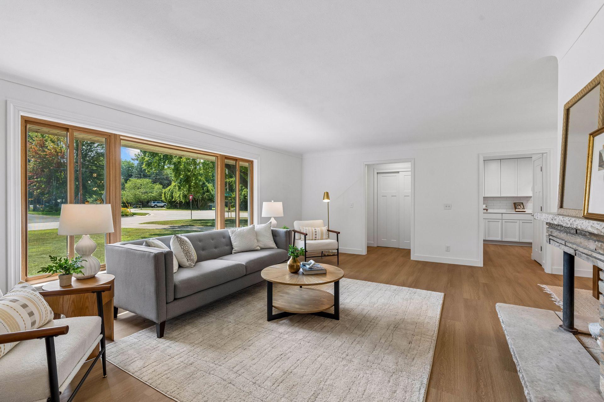 25x15 and 11x9 Living room and dining room with south and north-facing updated windows, new paint, new luxury vinyl flooring, and lighting.