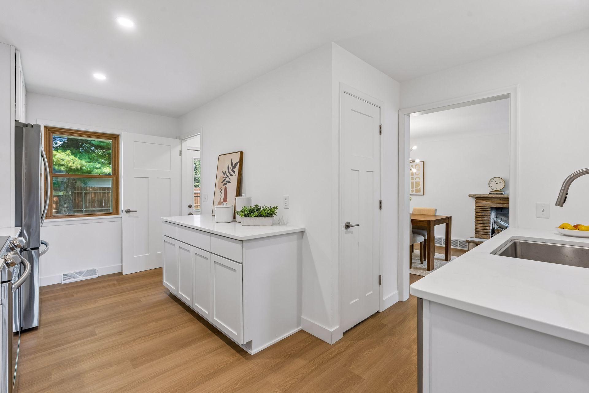 23x12 main Floor Kitchen with south and north-facing updated windows, new paint, new luxury vinyl flooring, and lighting. New shaker-style cabinets, stainless steel appliances, new dishwasher, new quartz countertops, new Undermount sink, and faucet.