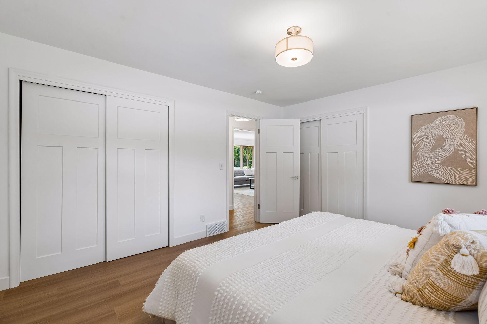14x12 Main floor Bedroom #1 with East and north-facing updated windows, new paint, New trim and closet doors, new luxury vinyl flooring, and lighting.