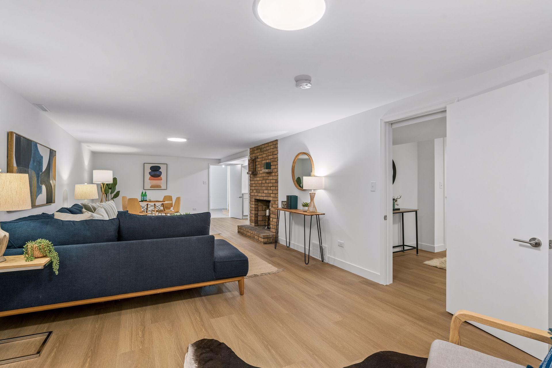 34x14 Lower-level family room with East-facing updated glass block windows, new paint, new luxury vinyl flooring, and lighting.