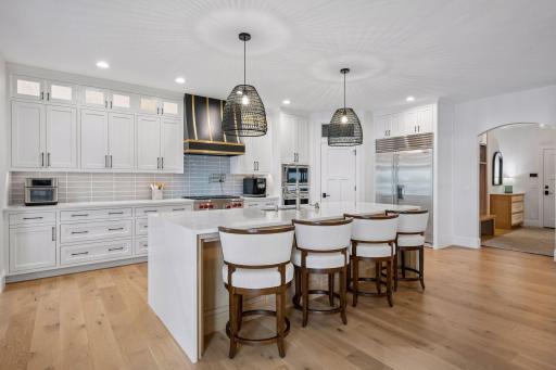 Stunning kitchen with white oak hardwood flooring, wolf & subzero appliances, walk in pantry and large center island with quartzite counter tops.