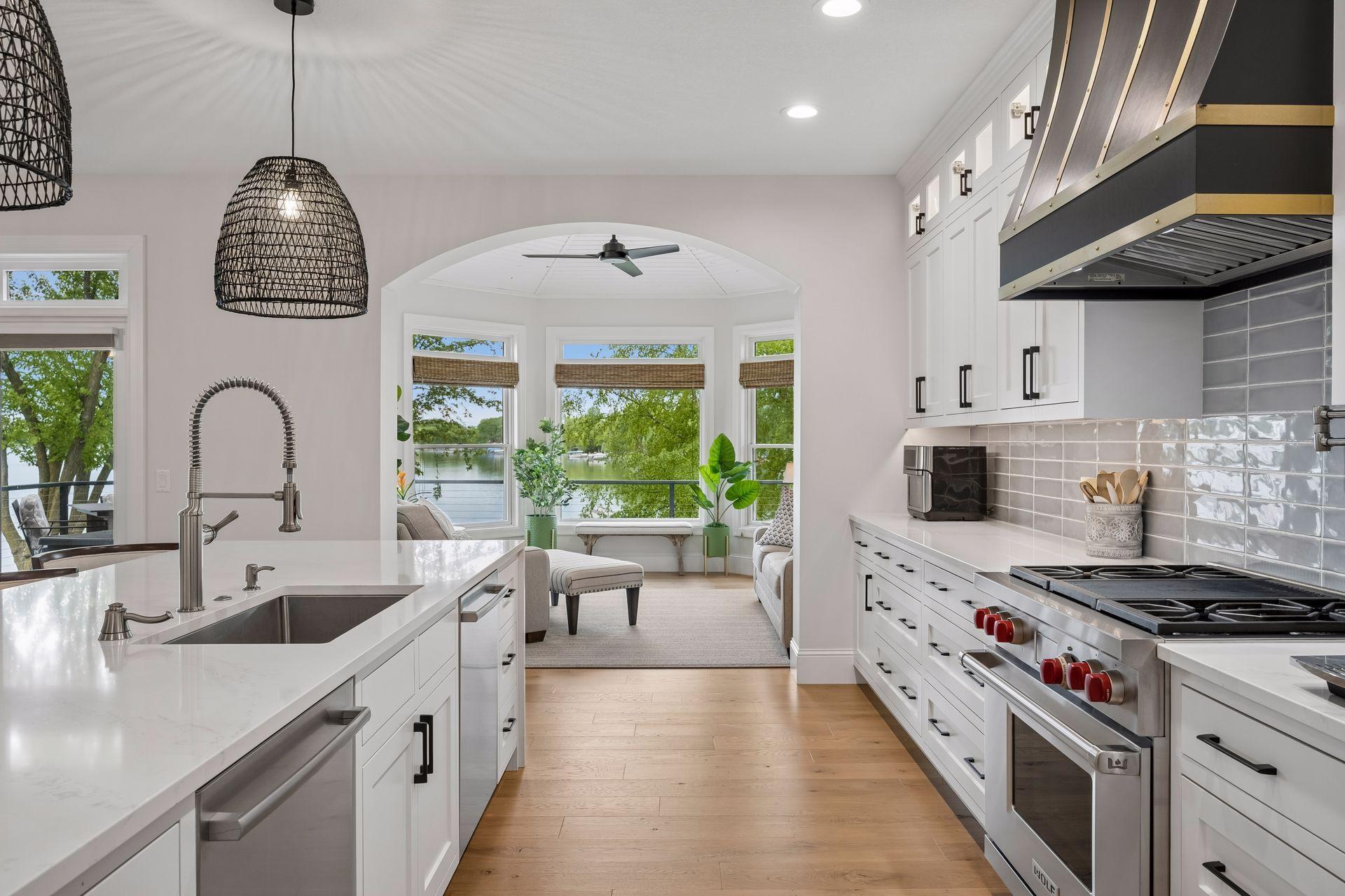 Stunning kitchen with white oak hardwood flooring, wolf & subzero appliances, walk in pantry and large center island with quartzite counter tops. Just off the kitchen a sun room to take in panoramic views of the lake.