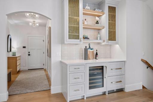 A view of entrance from the garage & dry bar with wine cooler and 2 beverage cooler drawers