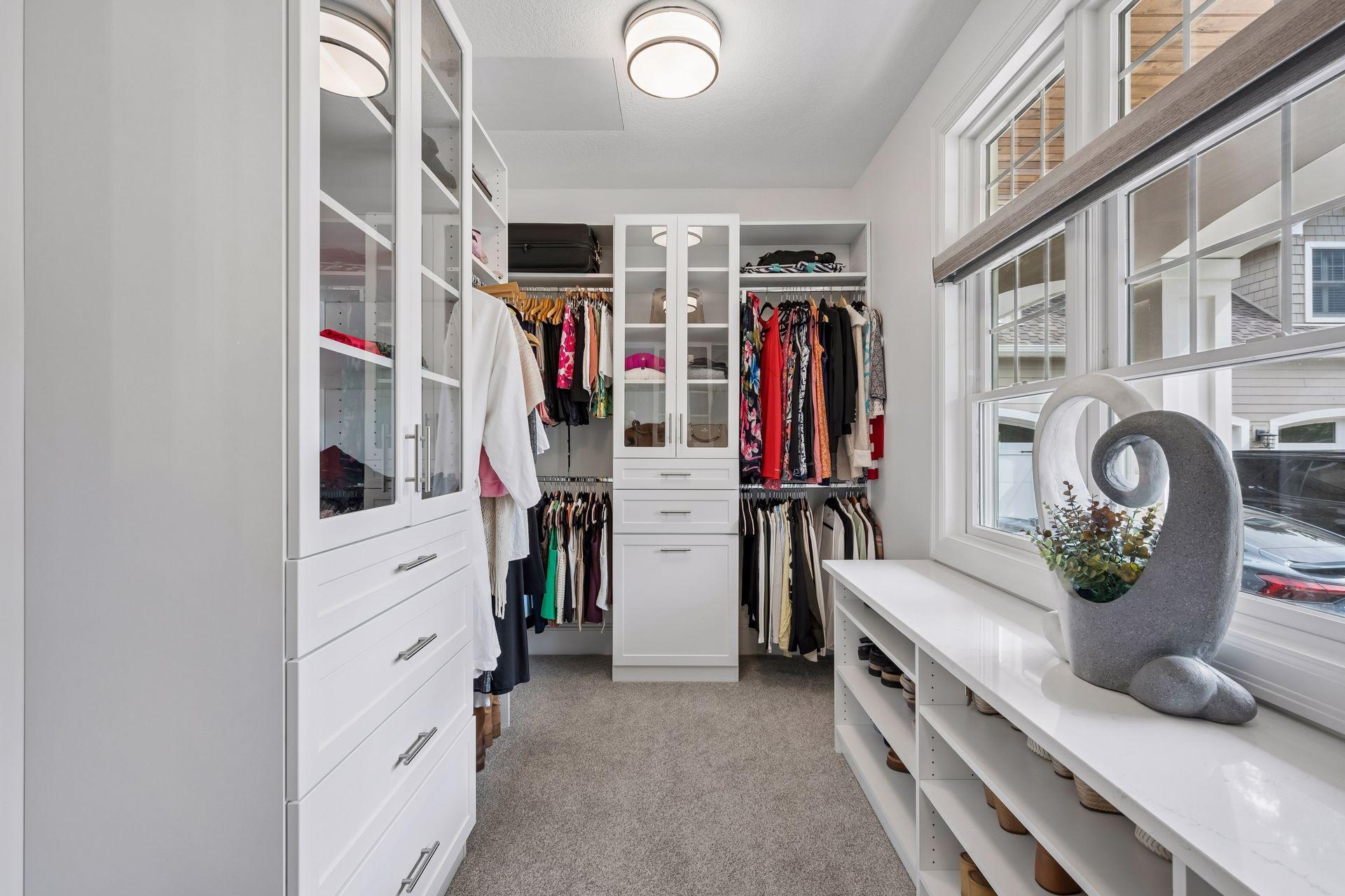 Walk in closet with custom closet organizing system.
