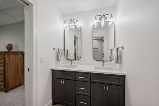 Private bathroom (bedroom 2 ) double vanity, granite counter tops, tile floors and tub with tile surround.