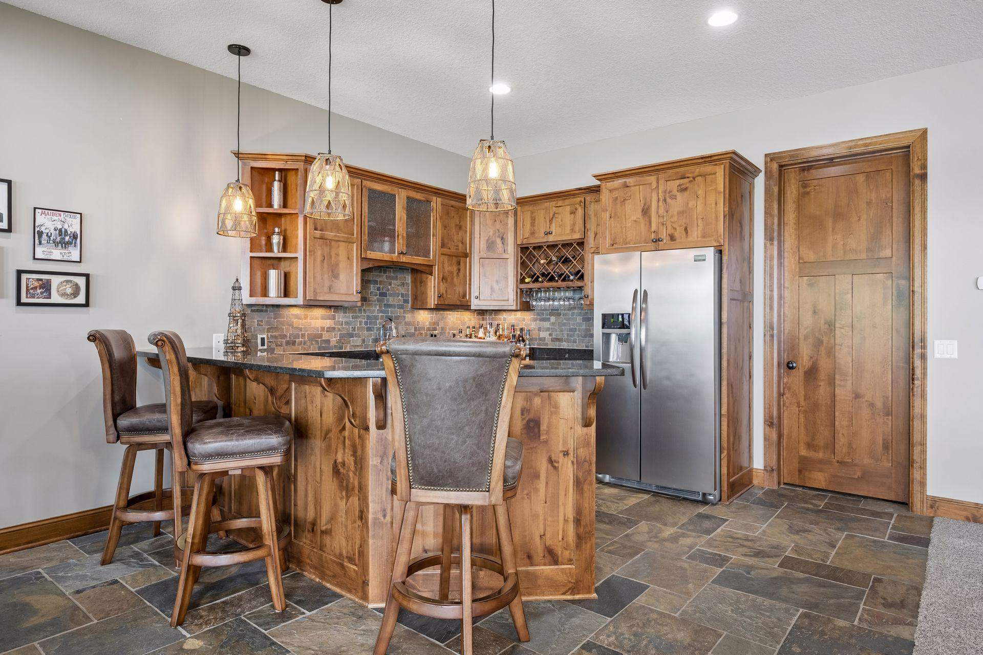 walkout lower level was built for entertaining with soaring 10-foot ceilings, knotty alder trim and doors, custom built-ins, oversized lake-facing windows, full wet bar with granite countertops, full-size refrigerator, dishwasher,