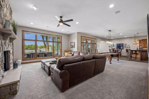 walkout lower level was built for entertaining with soaring 10-foot ceilings, knotty alder trim and doors, custom built-ins, oversized lake-facing windows, full wet bar with granite countertops, full-size refrigerator, dishwasher,