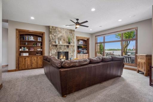 walkout lower level was built for entertaining with soaring 10-foot ceilings, knotty alder trim and doors, custom built-ins, oversized lake-facing windows, full wet bar with granite countertops, full-size refrigerator, dishwasher,
