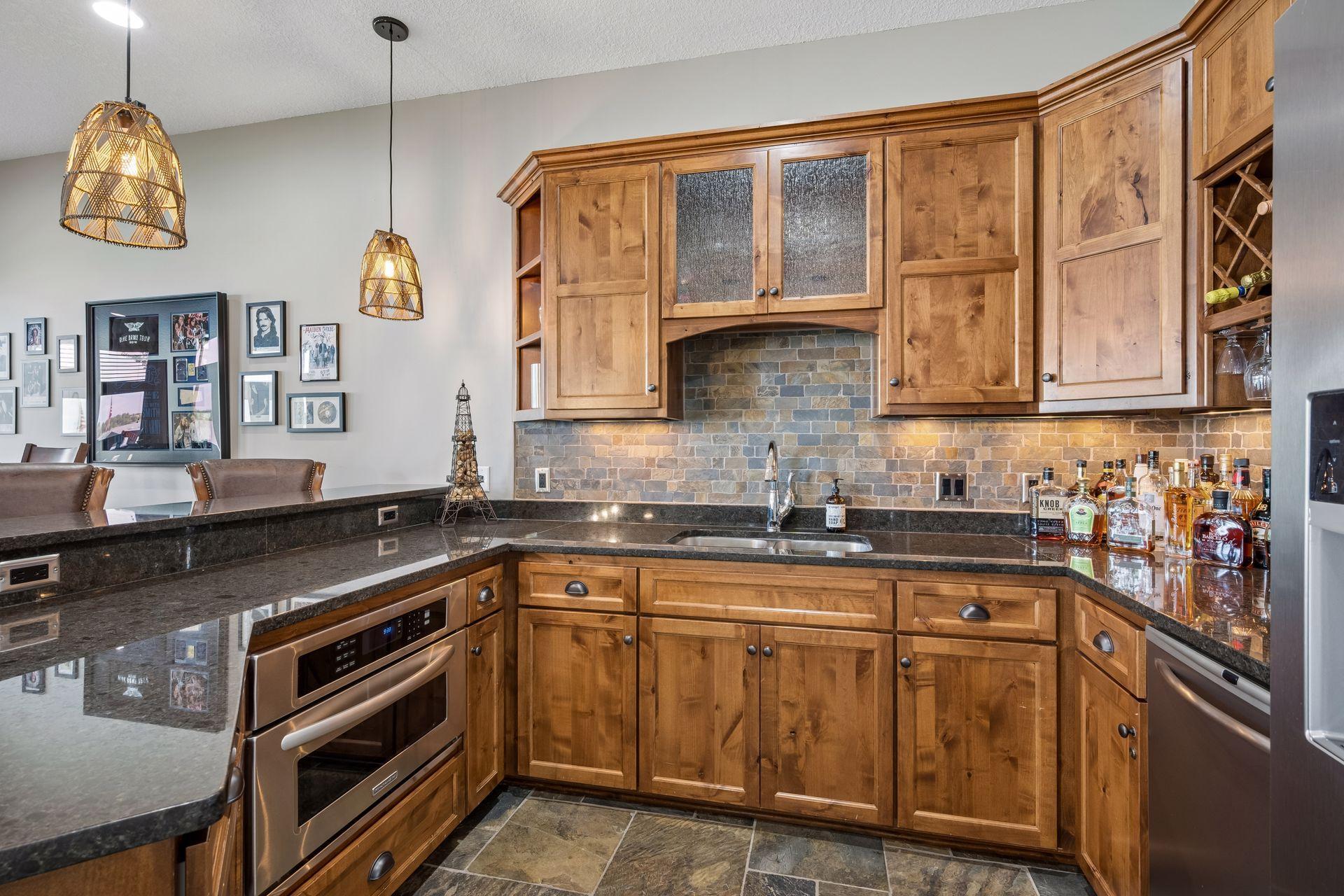 walkout lower level was built for entertaining with soaring 10-foot ceilings, knotty alder trim and doors, custom built-ins, oversized lake-facing windows, full wet bar with granite countertops, full-size refrigerator, dishwasher,