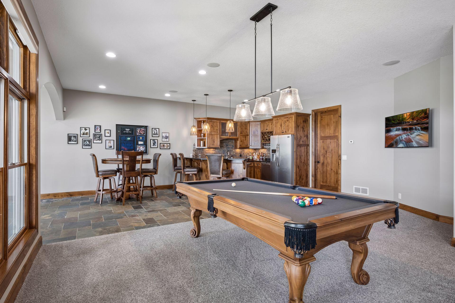 walkout lower level was built for entertaining with soaring 10-foot ceilings, knotty alder trim and doors, custom built-ins, oversized lake-facing windows, full wet bar with granite countertops, full-size refrigerator, dishwasher,