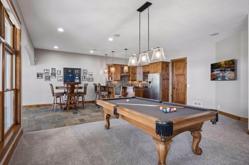walkout lower level was built for entertaining with soaring 10-foot ceilings, knotty alder trim and doors, custom built-ins, oversized lake-facing windows, full wet bar with granite countertops, full-size refrigerator, dishwasher,