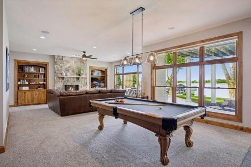 walkout lower level was built for entertaining with soaring 10-foot ceilings, knotty alder trim and doors, custom built-ins, oversized lake-facing windows, full wet bar with granite countertops, full-size refrigerator, dishwasher,