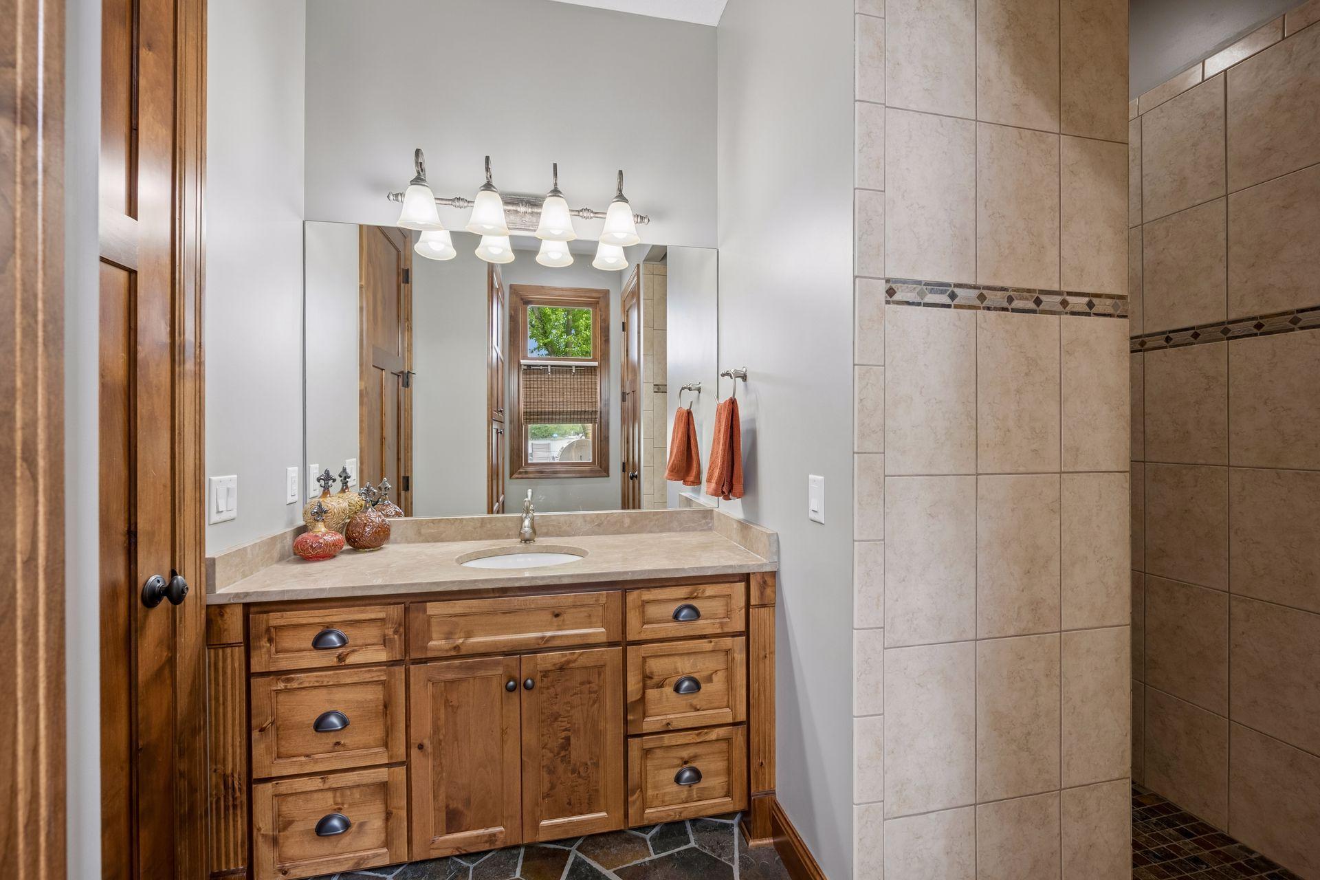 Lower level 3/4 bathroom with tile floors, granite counter tops, walk in shower with dual shower heads.