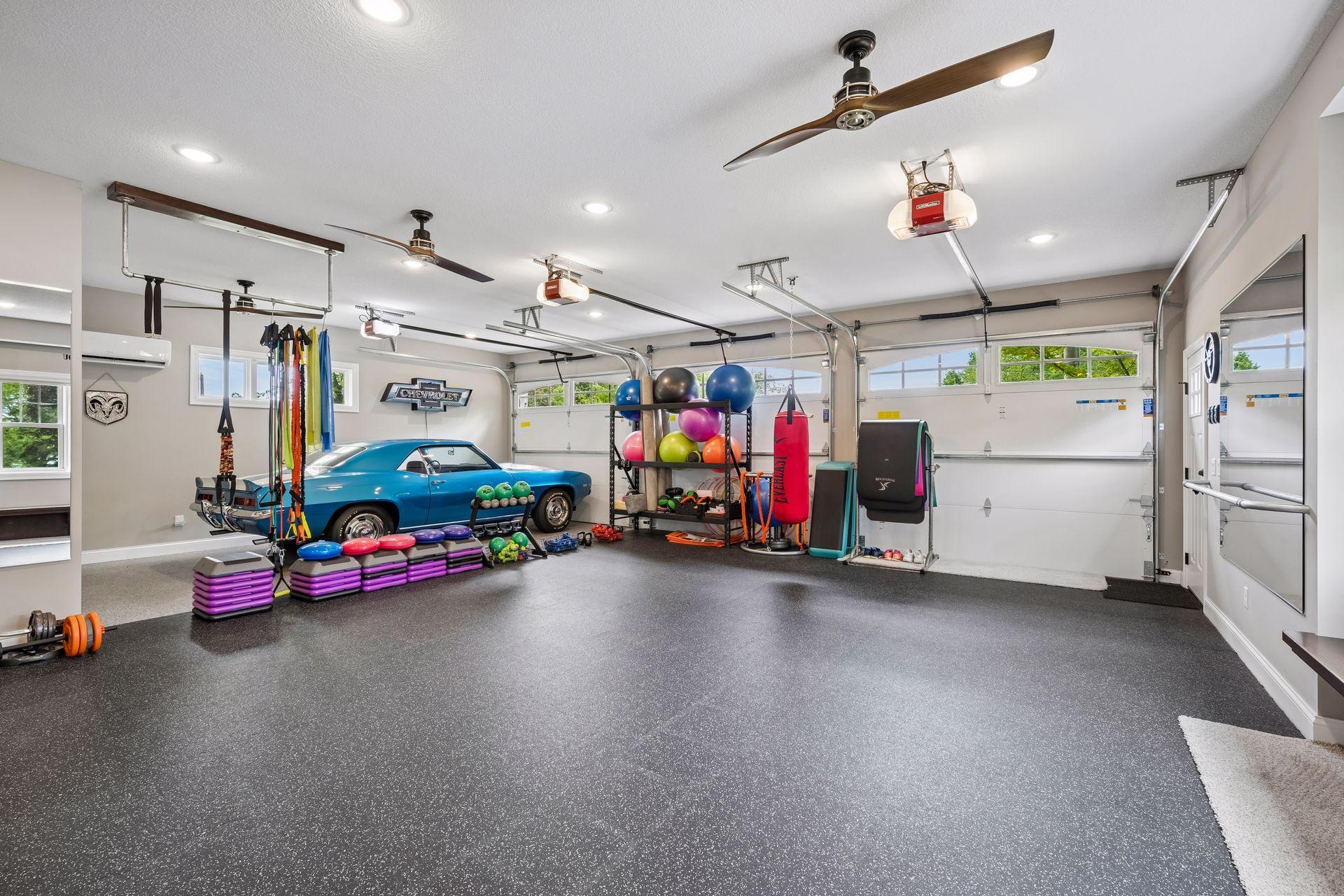 Interior of detached garage. Currently being used as a work out space. Features a epoxy floors, 1/2 bathroom, heat, AC, bonus room above and separate storage for lawn equipment.