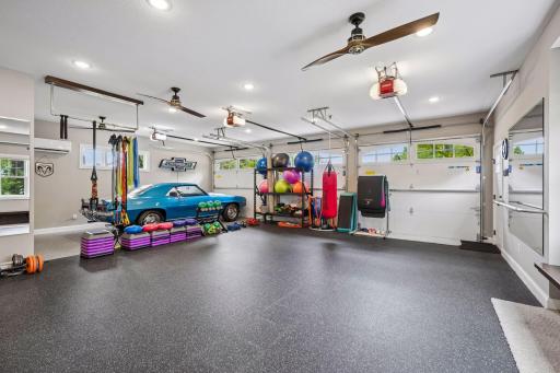 Interior of detached garage. Currently being used as a work out space. Features a epoxy floors, 1/2 bathroom, heat, AC, bonus room above and separate storage for lawn equipment.