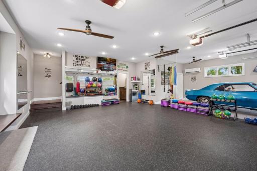 Interior of detached garage. Currently being used as a work out space. Features a epoxy floors, 1/2 bathroom, heat, AC, bonus room above and separate storage for lawn equipment.