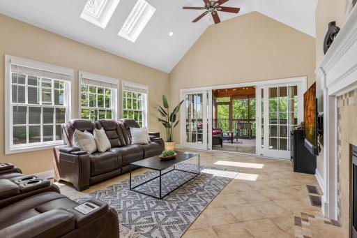 Formal living and dining rooms offer sophisticated entertaining spaces, while the vaulted sunroom provides a peaceful, light-filled retreat warmed by heated floors.