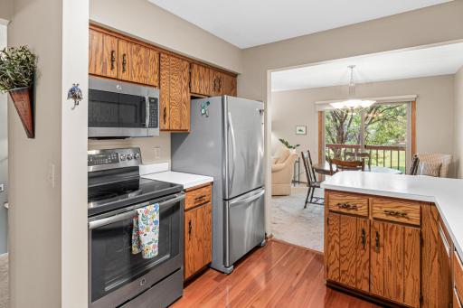 The kitchen is conveniently located adjacent to the dining area, providing an efficient layout for everyday living and meal preparation. Newer laminate flooring, appliances, fixtures and paint.
