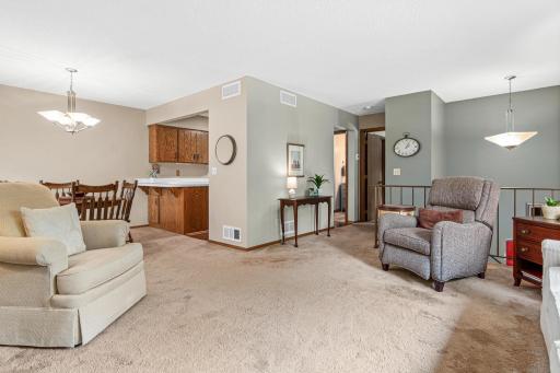 The inviting living room offers a comfortable space to relax or entertain and flows seamlessly into the informal dining area, creating an open and connected main living space.