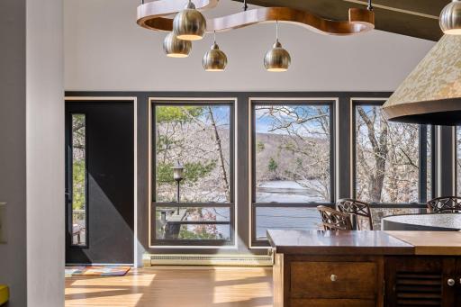 Mid-century modern influence with exposed beams, dramatic lines, and walls of windows that fill the home with natural light and surrounding views