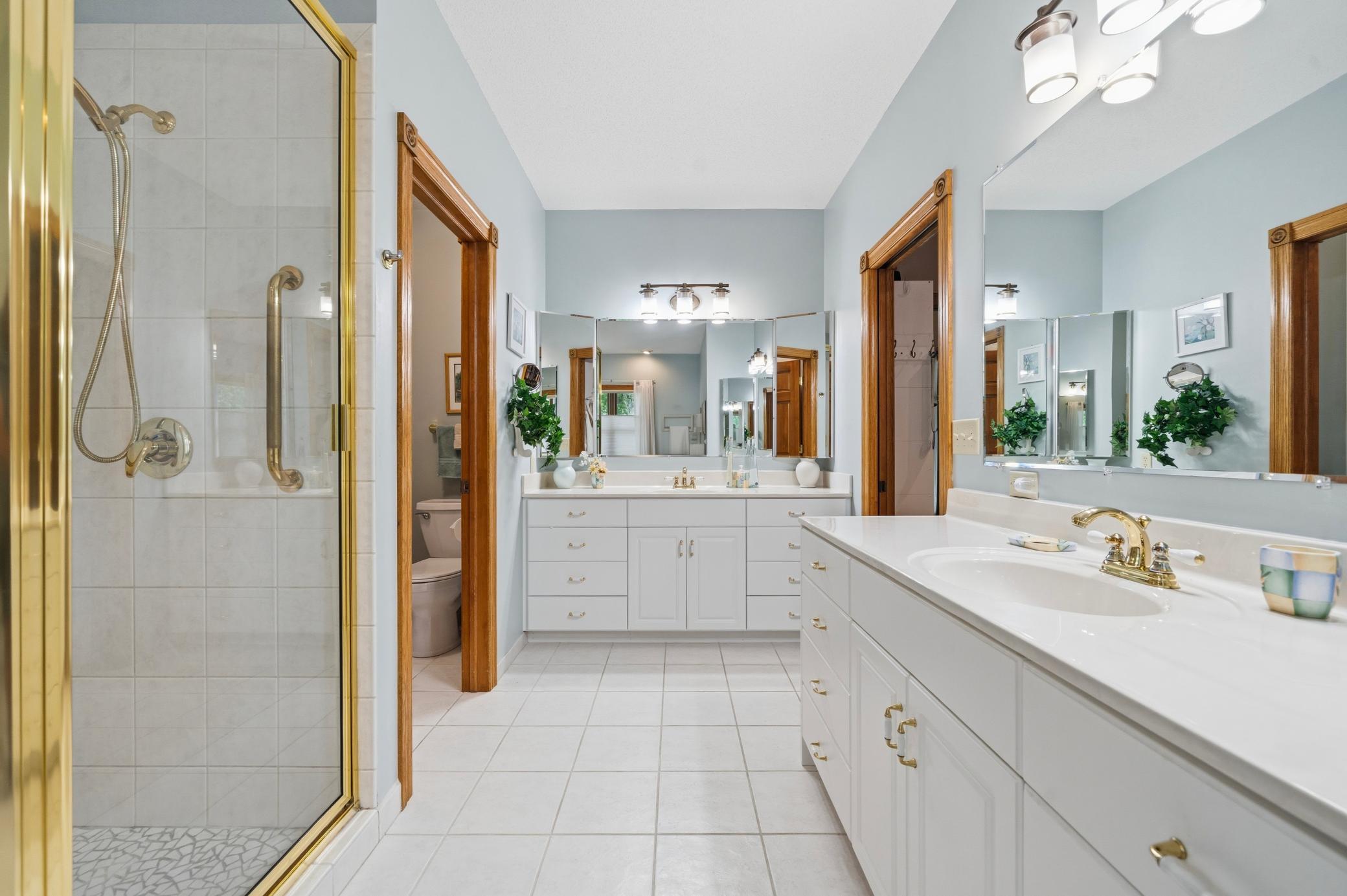 The private ensuite bath features dual vanities, a relaxing tub, and a separate walk-in shower.