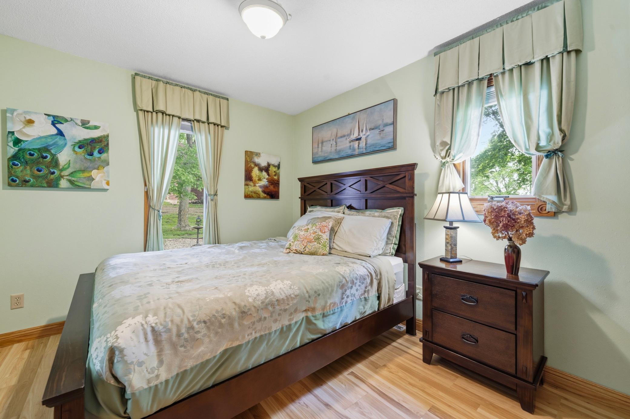 Second main floor bedroom with gleaming hard surface floors and dual windows for abundant natural light.