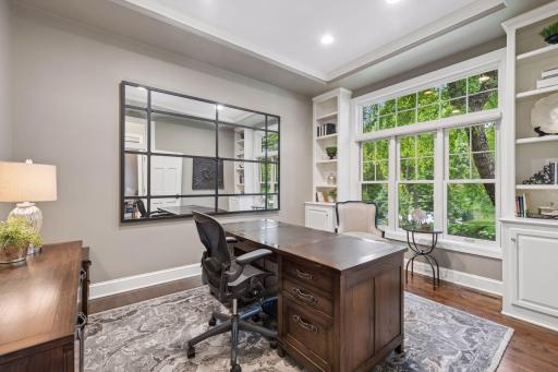 Tucked behind French doors, the home office offers a quiet retreat for work, reading, or creative pursuits, with peaceful views of the front gardens.