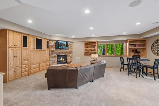 Warm and inviting, the lower-level family room offers another comfortable gathering space, where a gas fireplace and custom built-ins create the perfect setting for movie nights or quiet evenings at home.