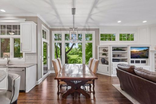 A casual dining area ties together the living room and kitchen while large windows fill the space with natural light while providing peaceful views of the surrounding wetland, a beautiful backdrop in every season.